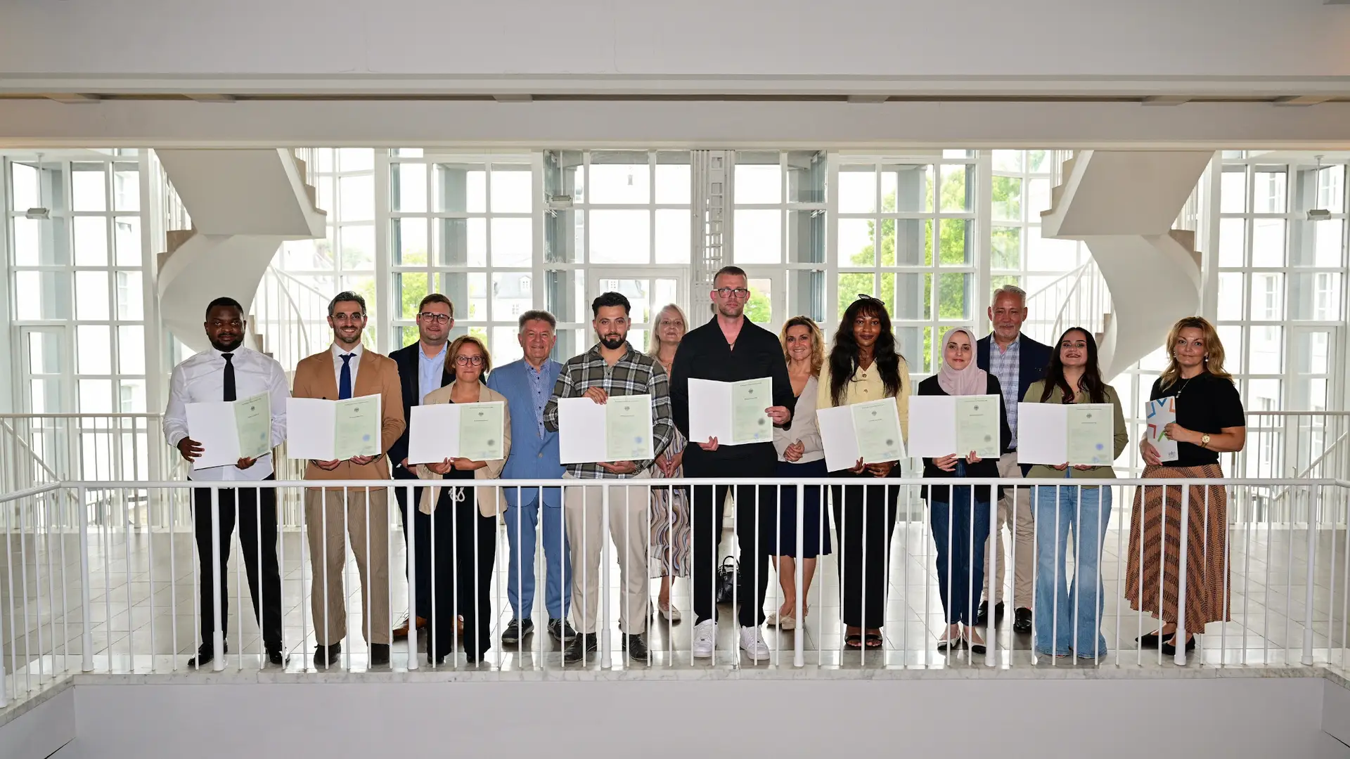 Der Ehrenamtliche Beigeordnete des Regionalverbands Manfred Maurer (5.v.l.), der Friedrichsthaler Bürgermeister Christian Jung (2.v.r.), die Beigeordneten Daniela Morsch aus Sulzbach, Dominik Blaes aus Riegelsberg und Kathrin Gross aus Kleinblittersdorf mit den Eingebürgerten im Saarbrücker Schloss.