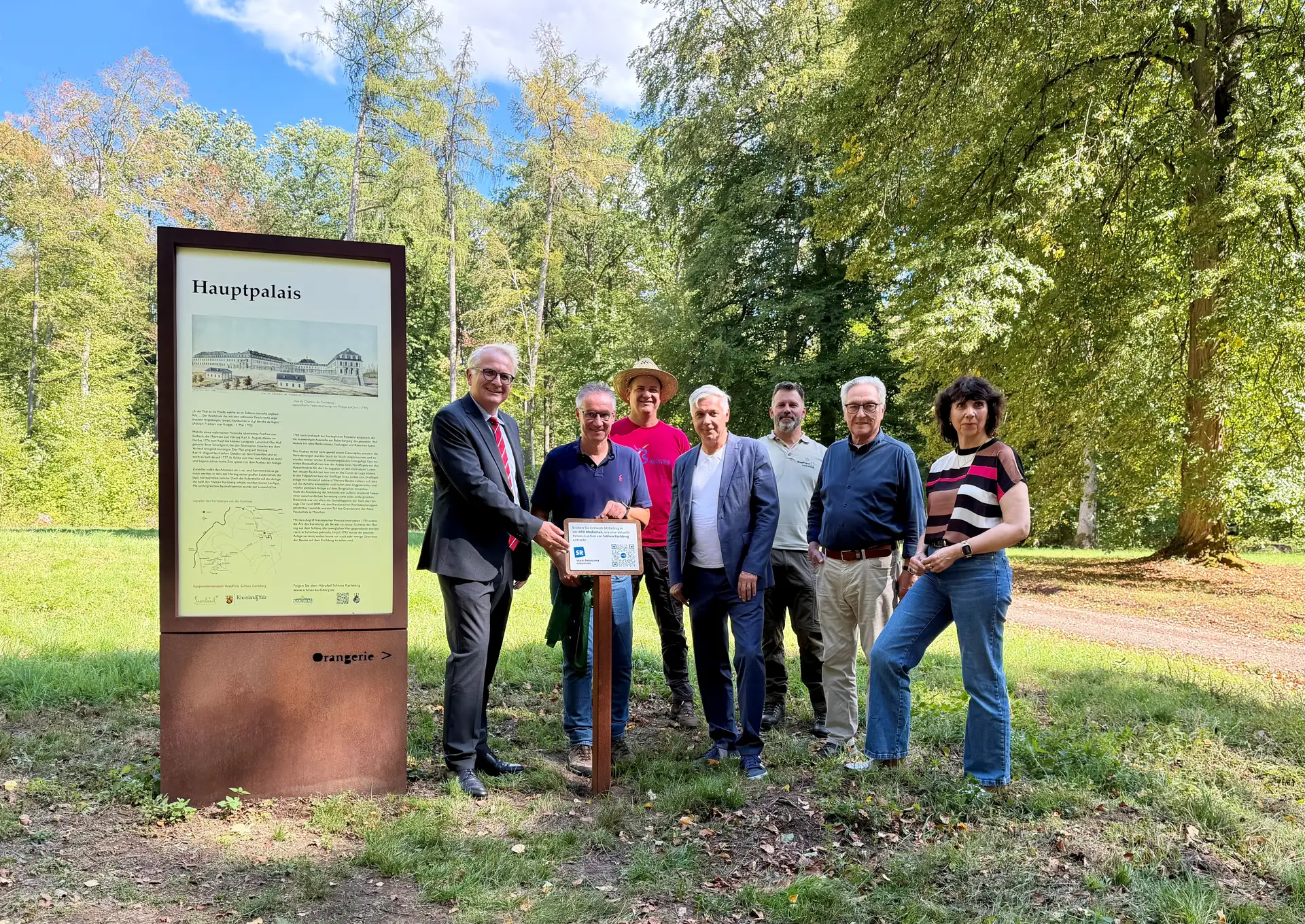 Dr. Frank Matheis, Landrat Frank John, Thomas Menges, Peter Meyer, Carsten Federspiel, Raimund Konrad und Dr. Jutta Schwan (von links) bei der Einweihung der SR-Plakette im WaldPark Schloss Karlsberg.