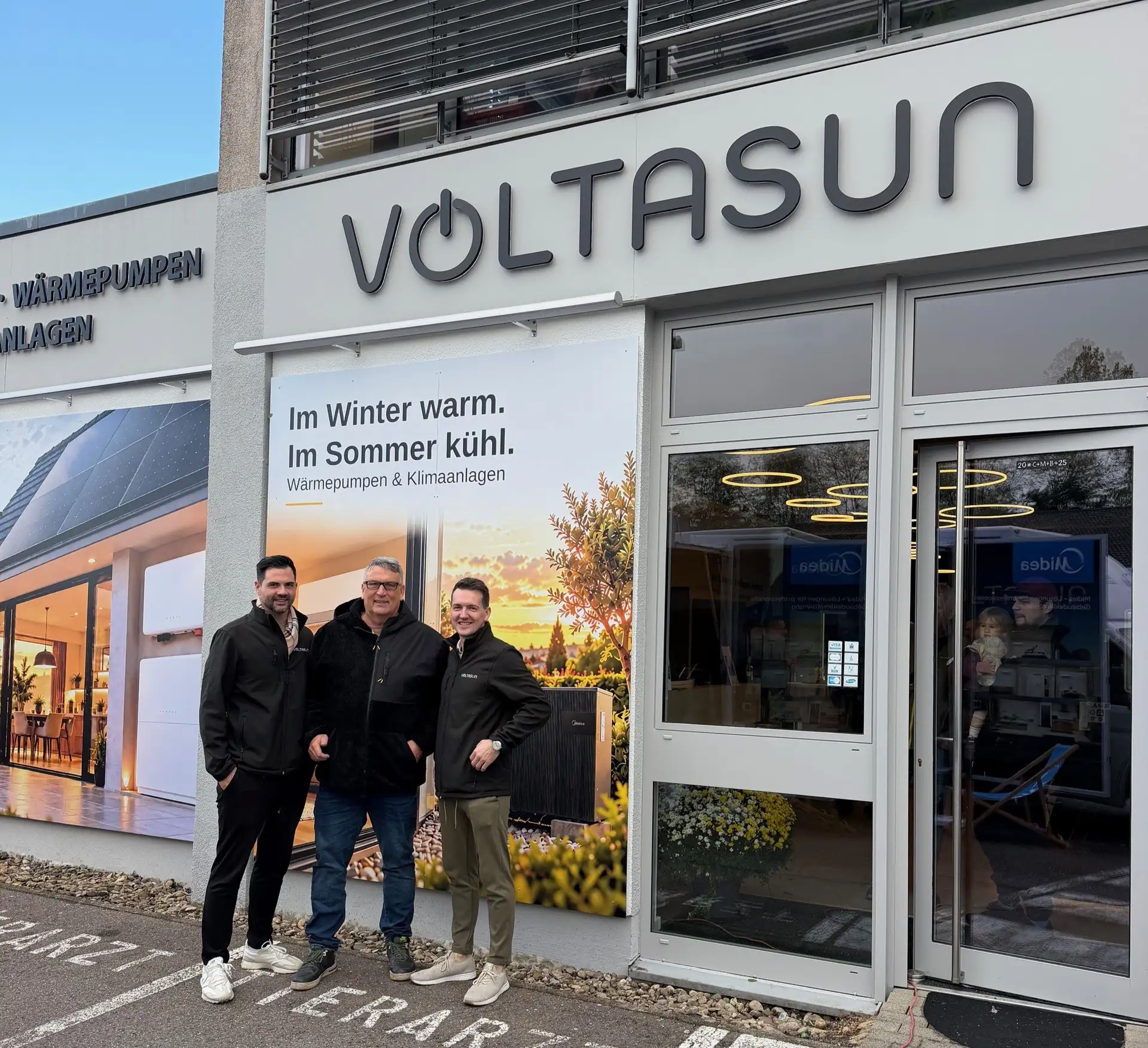 Die Geschäftsführer der Voltsun GmbH Benjamin Kunz (l.) und Christoph Krämer (r.) mit dem Beigeordneten Markus Schmitt (Mitte) vor dem neuen Kundencenter in der Otto-Touissant-Straße.