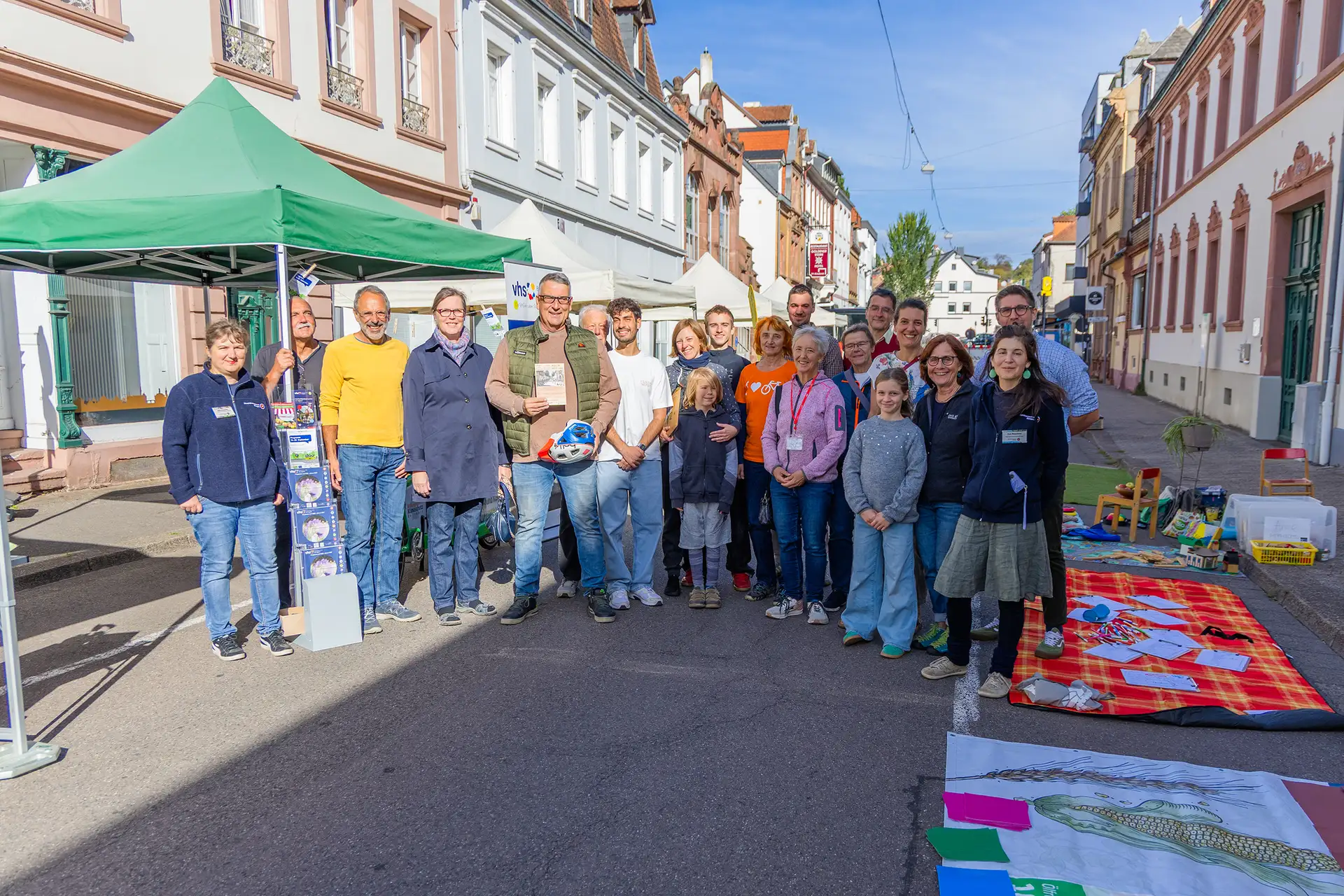 Menschen stehen vor einem im Straßenraum aufgebauten Infostand beim Parking Day in der Ludwigstraße.
