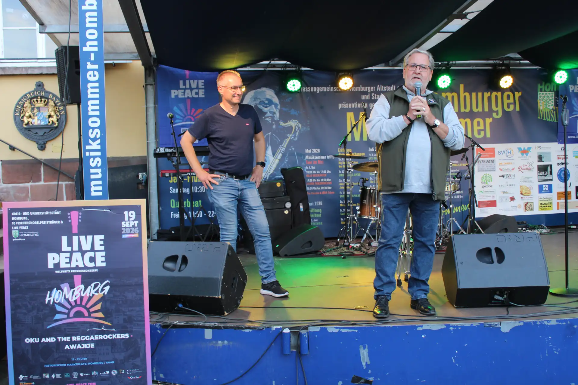 Mann bei einem Live-Konzert im Freien vor einer Bühne.