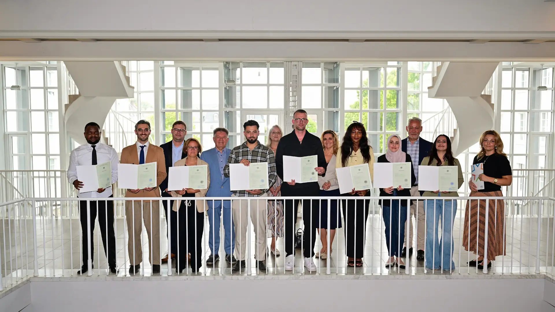 Der Ehrenamtliche Beigeordnete des Regionalverbands Manfred Maurer (5.v.l.), der Friedrichsthaler Bürgermeister Christian Jung (2.v.r.), die Beigeordneten Daniela Morsch aus Sulzbach, Dominik Blaes aus Riegelsberg und Kathrin Gross aus Kleinblittersdorf mit den Eingebürgerten im Saarbrücker Schloss.